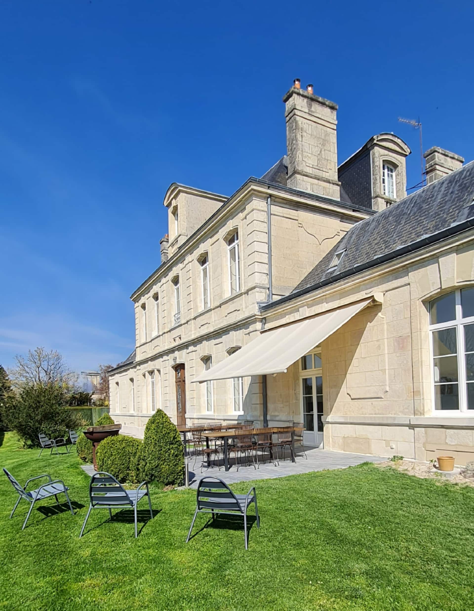 Terrasse côté jardin avec mobilier et store